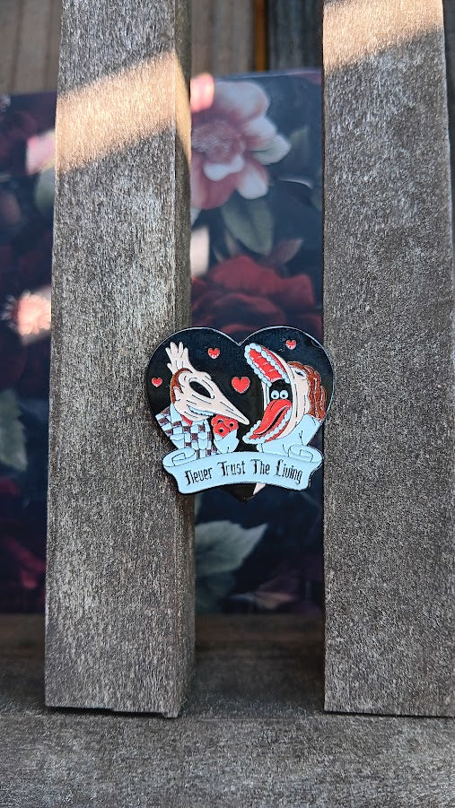 Pin with two dogs in a heart shape on a textured surface